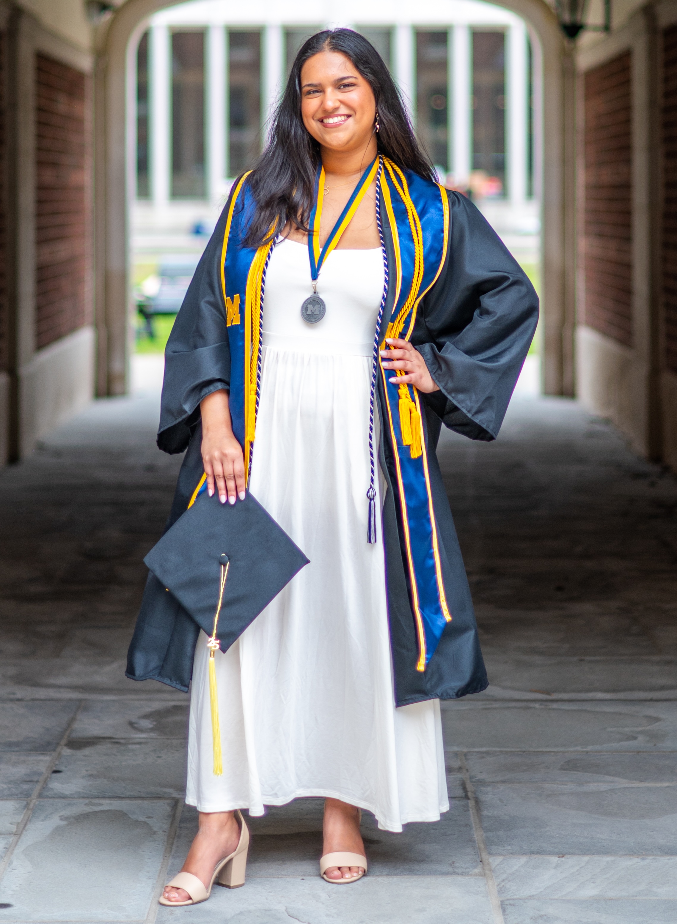 One of Aayana's Umich Senior Photos showing her posed in front of East Quadrangle